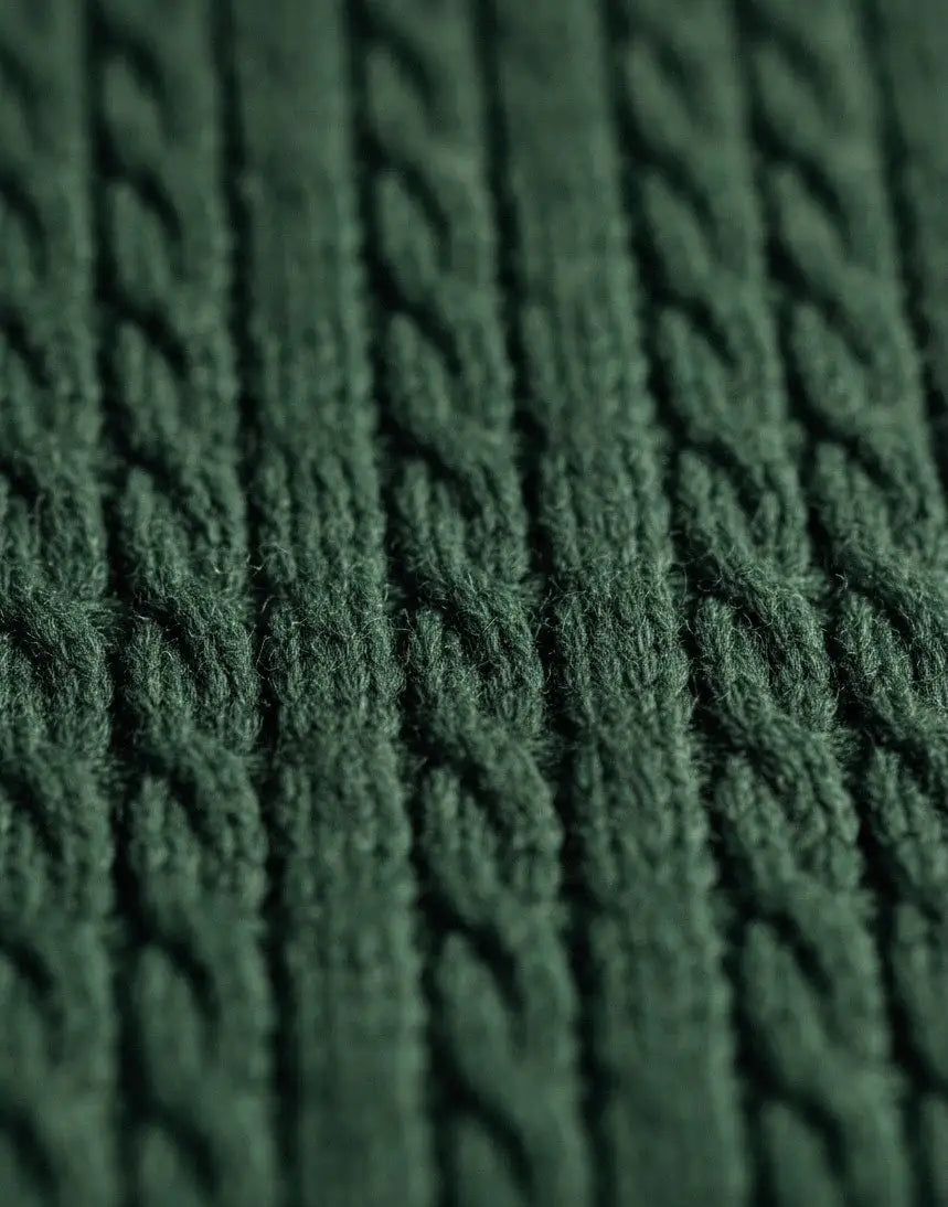 Close-up of textured green fabric with a  cable pattern