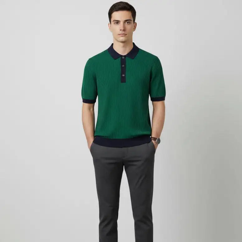 Man wearing a Green pure BCI Cotton polo shirt with navy trim and gray pants on a light gray background