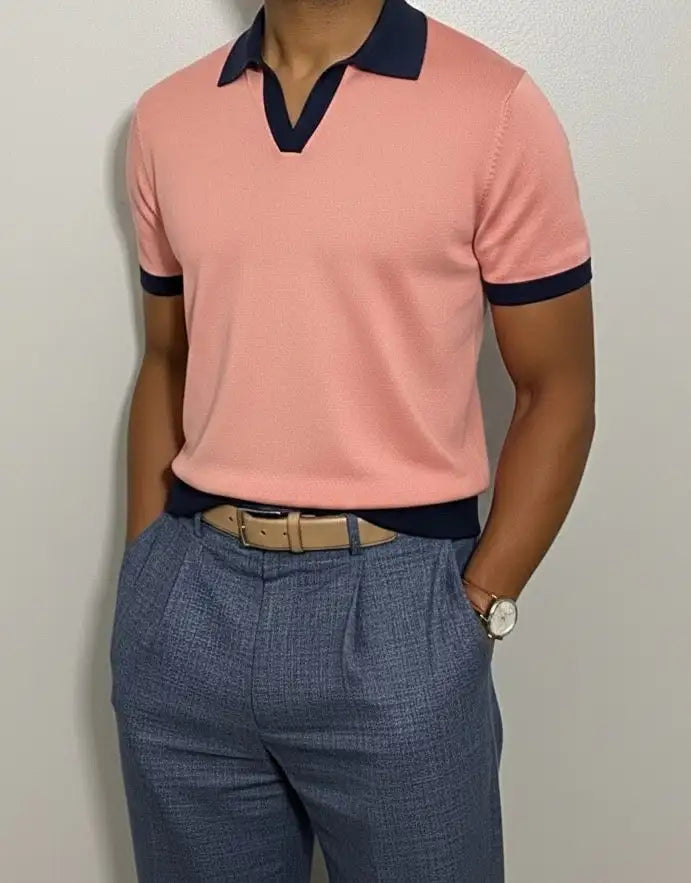 Person wearing a Salmon v-neck polo shirt with navy accents and blue pants against a plain background